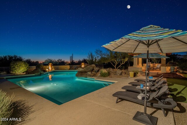 pool at dusk featuring a patio