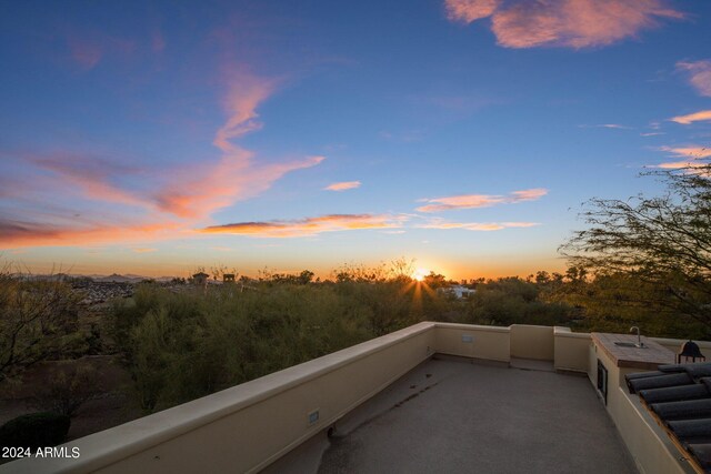 patio terrace at dusk featuring a balcony