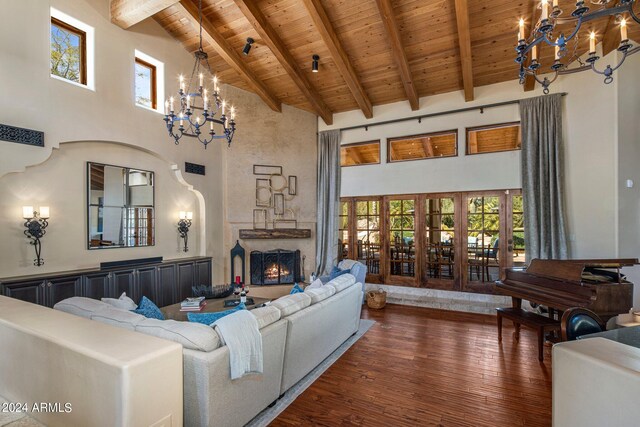 living room featuring dark wood-type flooring, high vaulted ceiling, wooden ceiling, beam ceiling, and an inviting chandelier