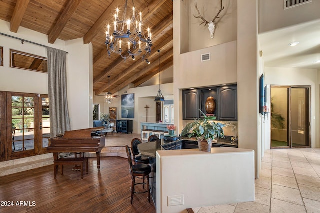 living area with beamed ceiling, high vaulted ceiling, visible vents, and wood ceiling