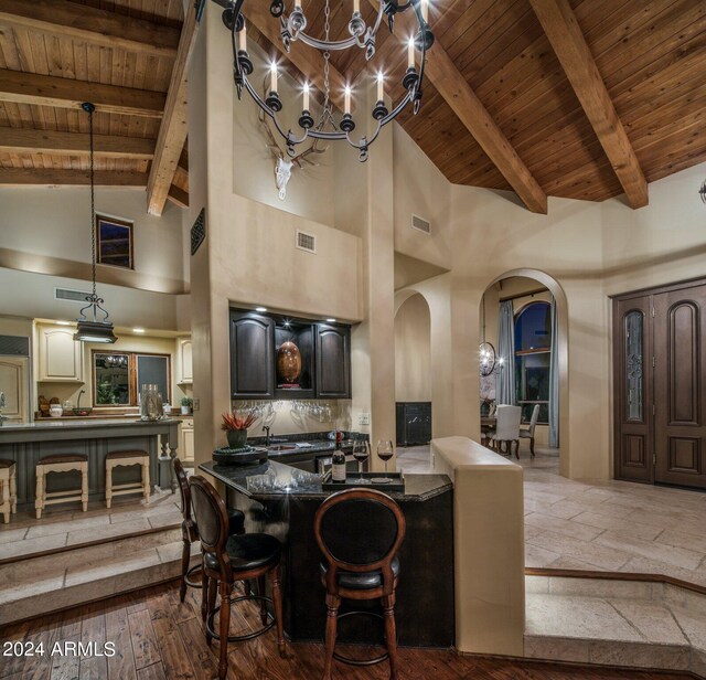 kitchen featuring a chandelier, dark wood-type flooring, high vaulted ceiling, and wooden ceiling