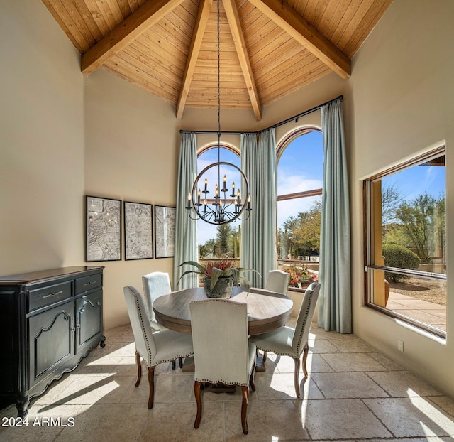 dining area with high vaulted ceiling, a chandelier, wood ceiling, beam ceiling, and stone tile flooring