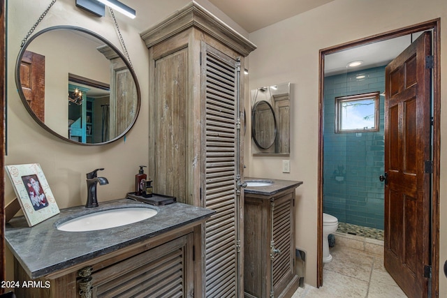 full bathroom with toilet, a stall shower, two vanities, and a sink