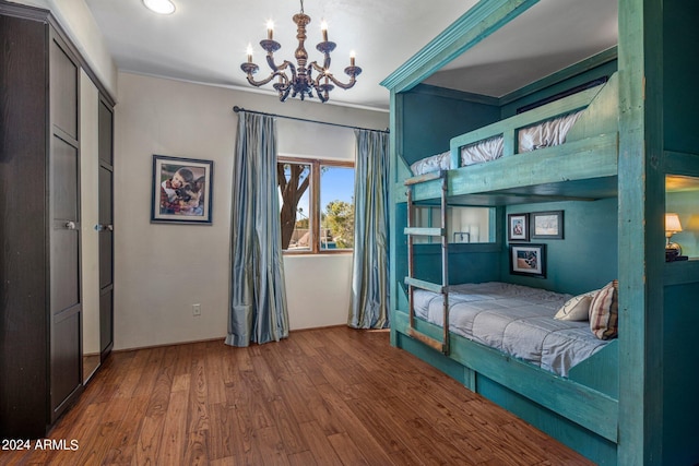 bedroom with crown molding, wood finished floors, and an inviting chandelier