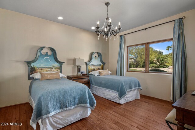 bedroom with an inviting chandelier and wood-type flooring