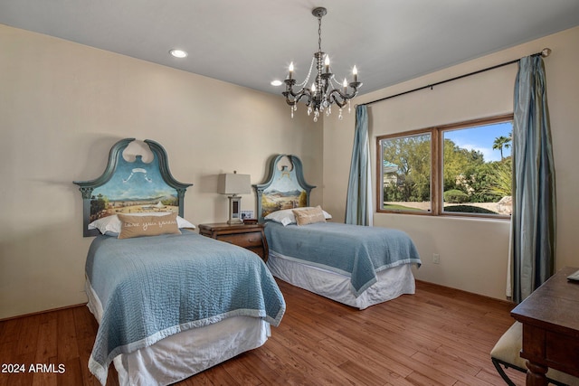 bedroom featuring recessed lighting, a notable chandelier, and wood finished floors