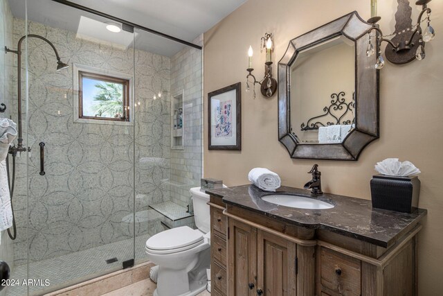 bathroom featuring vanity, toilet, and a shower with shower door