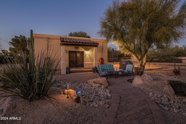 exterior space with outdoor lounge area, french doors, and fence