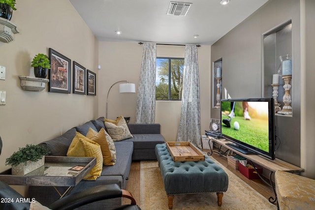 living area with wood finished floors, visible vents, and recessed lighting