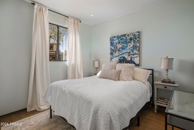 bedroom featuring wood finished floors and baseboards