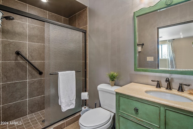 full bathroom featuring toilet, vanity, and a stall shower