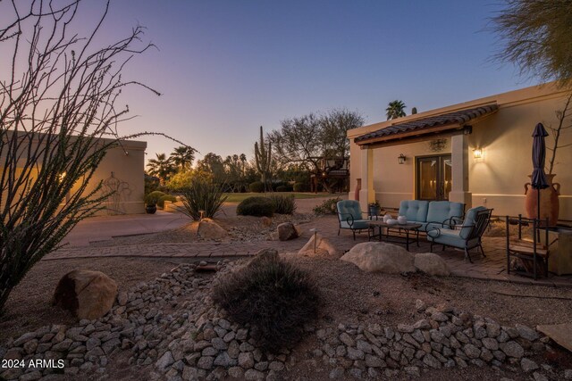 yard at dusk featuring a patio area and an outdoor hangout area