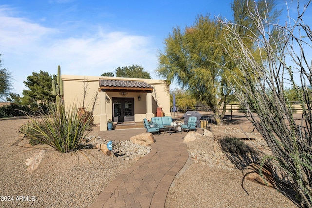 back of property featuring french doors, stucco siding, fence, and a tile roof