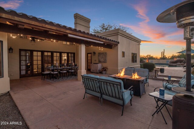 patio terrace at dusk featuring an outdoor living space with a fire pit