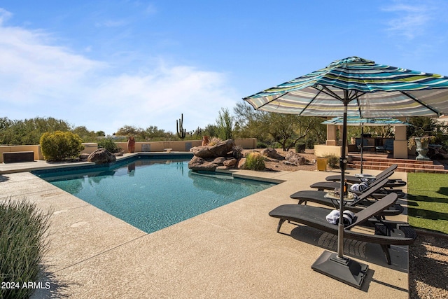 view of swimming pool featuring a patio area, a fenced in pool, and fence