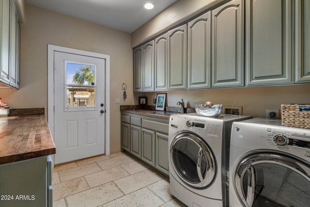 laundry room with cabinets, separate washer and dryer, and sink