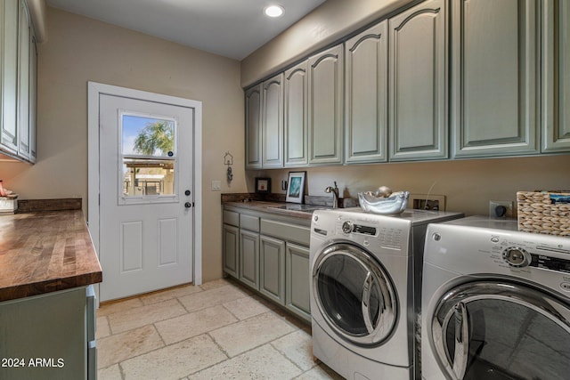 laundry room featuring separate washer and dryer, stone tile floors, recessed lighting, a sink, and cabinet space
