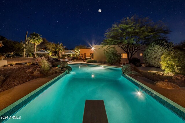 view of pool at twilight