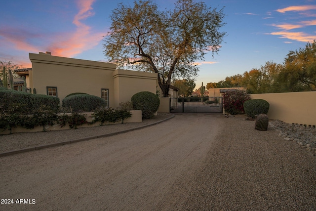 view of street featuring driveway, a gated entry, and a gate
