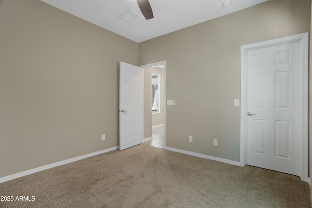 carpeted spare room featuring ceiling fan