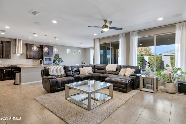 living room featuring sink, light tile patterned floors, and ceiling fan