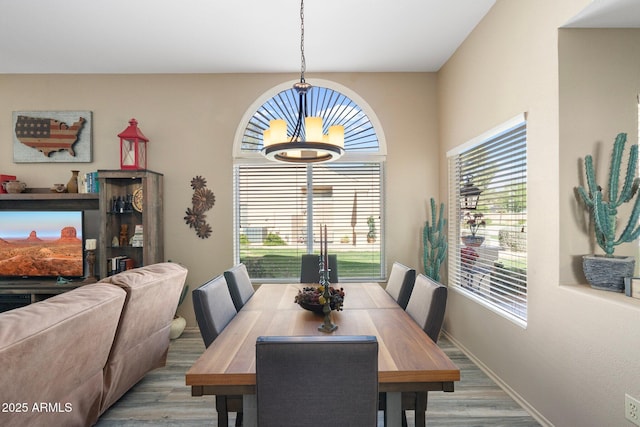 dining room featuring a healthy amount of sunlight, light wood-style floors, and an inviting chandelier