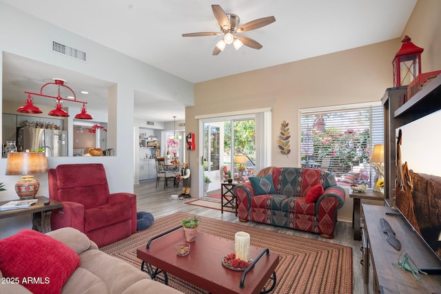 living area with wood finished floors, visible vents, and ceiling fan