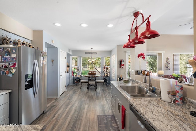 kitchen with a sink, decorative light fixtures, wood finished floors, recessed lighting, and stainless steel fridge with ice dispenser