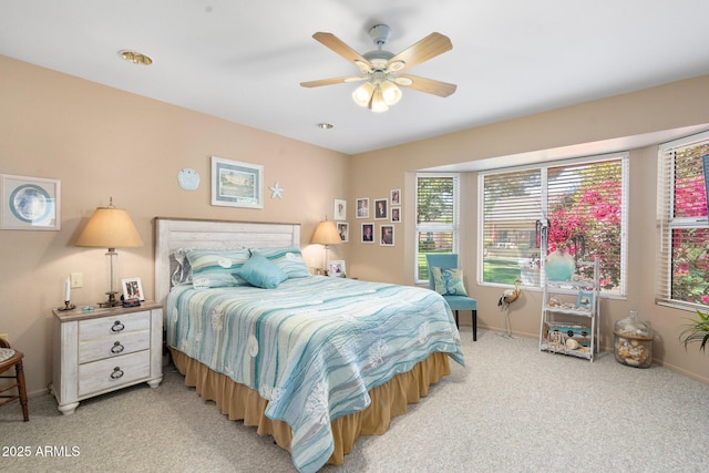 bedroom with a ceiling fan, light colored carpet, and baseboards