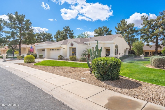 mediterranean / spanish home featuring stucco siding, a garage, concrete driveway, and a front lawn