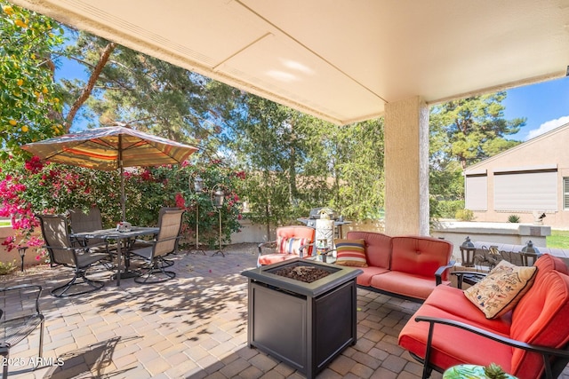 view of patio / terrace with an outdoor living space with a fire pit and outdoor dining area