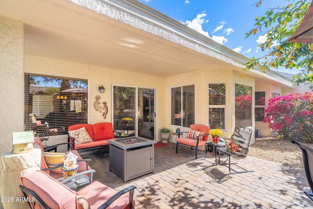 view of patio with an outdoor living space with a fire pit