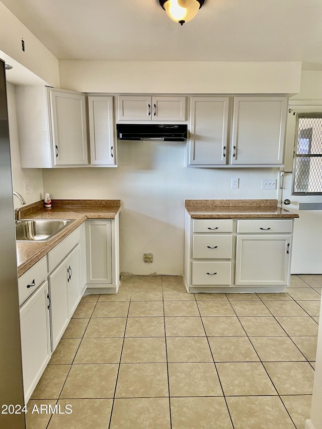 5522 E Colby St, Mesa, AZ 85205 - kitchen with under cabinet range hood, light tile patterned floors, white cabinetry, and freestanding refrigerator
