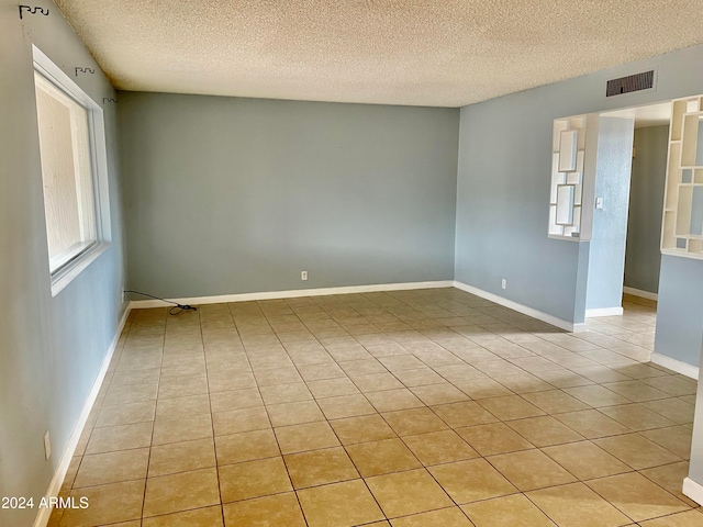 empty room featuring light tile patterned floors and a textured ceiling