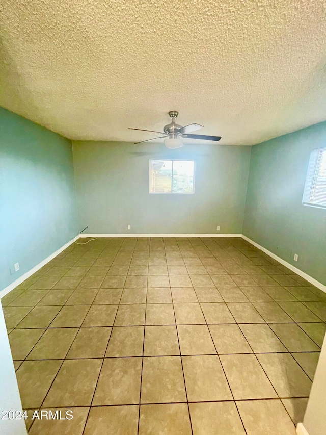 unfurnished room featuring tile patterned floors, ceiling fan, and a textured ceiling