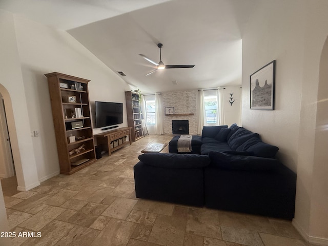 10029 S 44th St, Phoenix, AZ 85044 - living area featuring ceiling fan, stone tile flooring, a fireplace, arched walkways, and lofted ceiling