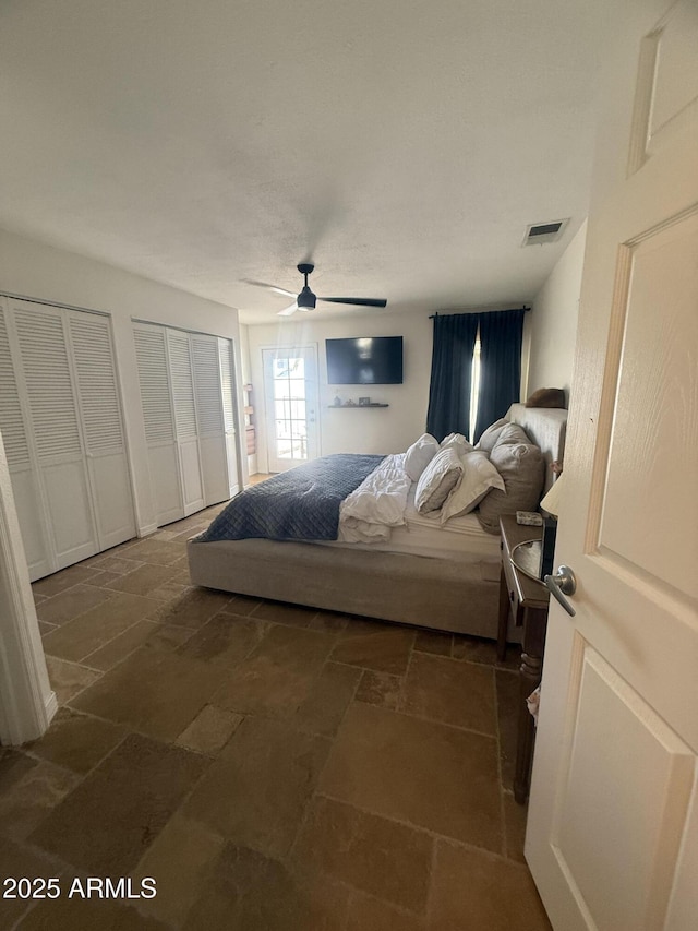 10029 S 44th St, Phoenix, AZ 85044 - bedroom featuring multiple closets, stone tile floors, and a ceiling fan