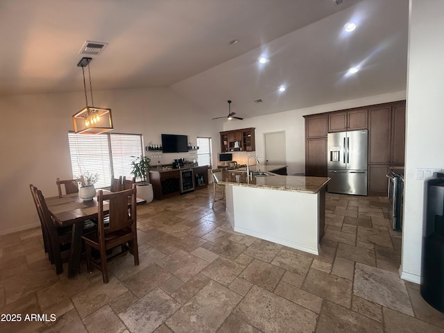 10029 S 44th St, Phoenix, AZ 85044 - kitchen with stainless steel refrigerator with ice dispenser, stone tile flooring, dark brown cabinets, a ceiling fan, and high vaulted ceiling