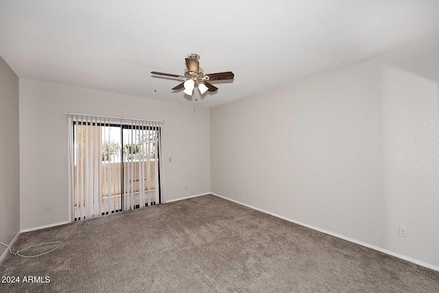 spare room featuring ceiling fan and dark carpet