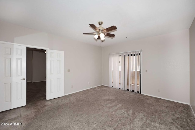 unfurnished room with ceiling fan and dark colored carpet