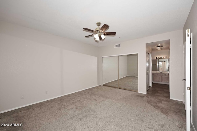 unfurnished bedroom with ceiling fan, a closet, carpet flooring, and connected bathroom