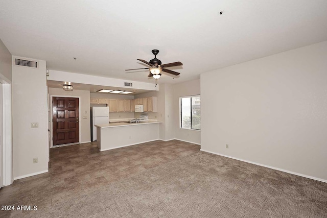 unfurnished living room featuring dark colored carpet and ceiling fan