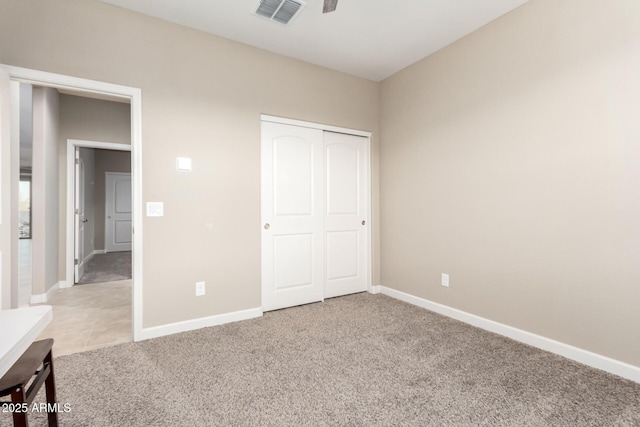 unfurnished bedroom featuring a closet and light colored carpet