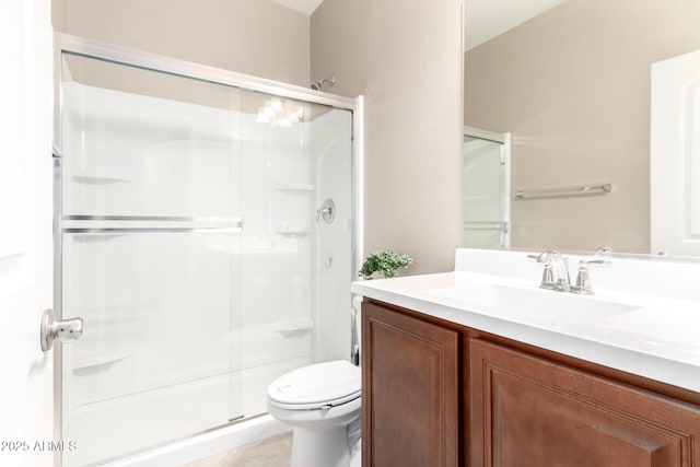 bathroom featuring vanity, toilet, and a shower with door