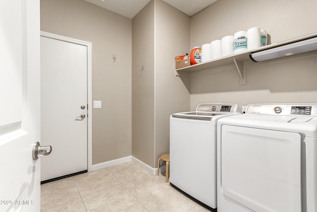 laundry room with washing machine and dryer and light tile patterned floors