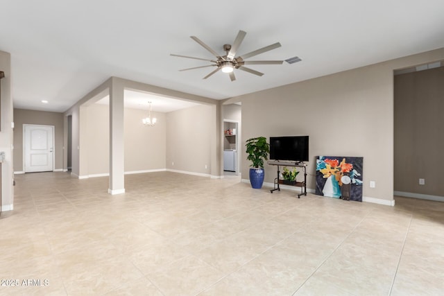 basement featuring light tile patterned floors and ceiling fan with notable chandelier