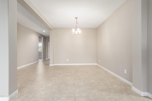 tiled empty room with an inviting chandelier