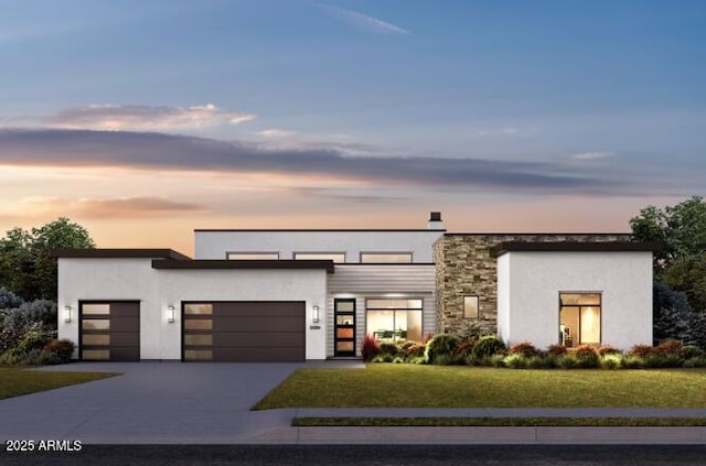 contemporary home with a garage, driveway, stone siding, a lawn, and stucco siding