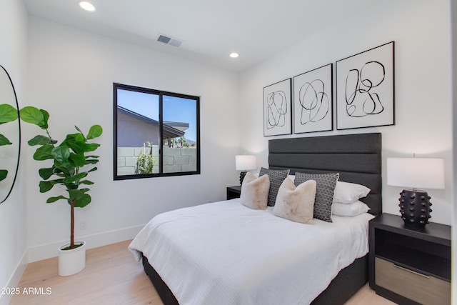 bedroom featuring baseboards, wood finished floors, visible vents, and recessed lighting