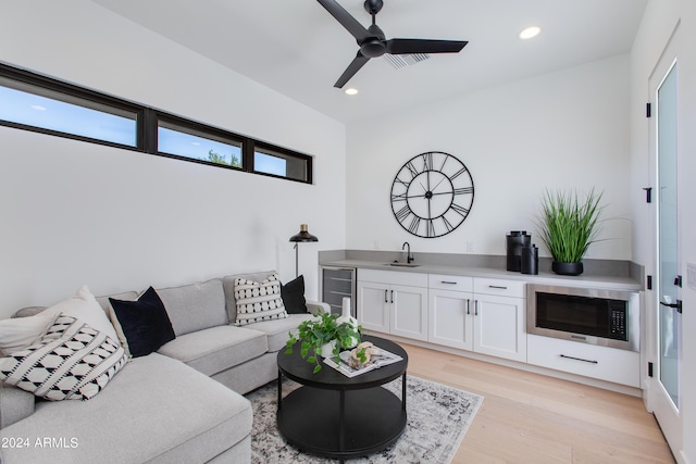 living room with indoor wet bar, light wood-type flooring, a ceiling fan, and recessed lighting